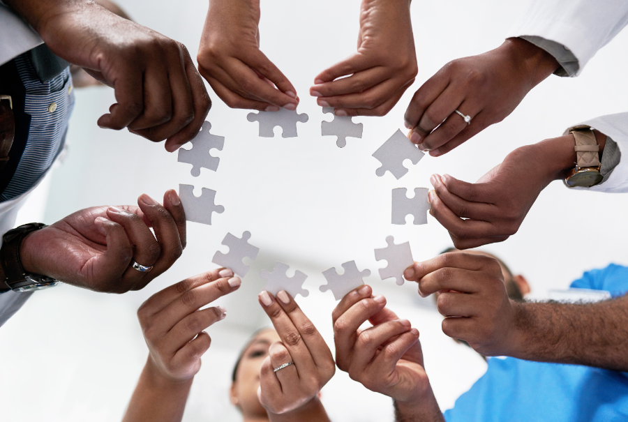 circle of hands with puzzle pieces